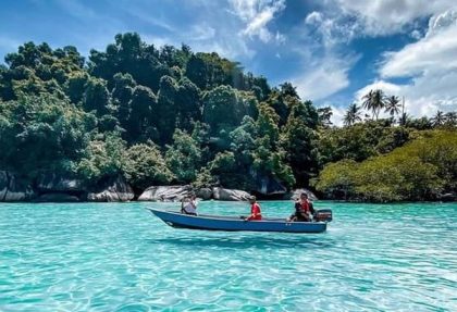 Boat in front of coral tulai island tioman