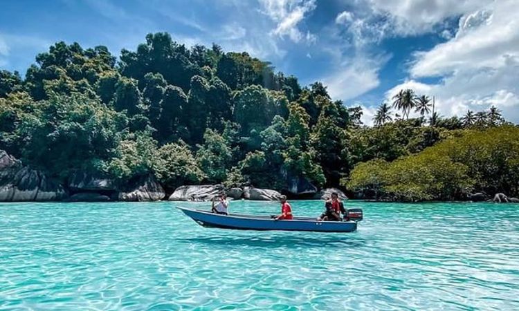 Boat in front of coral tulai island tioman