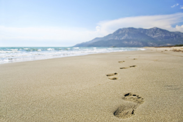 footprints on the beach mountains in the distance