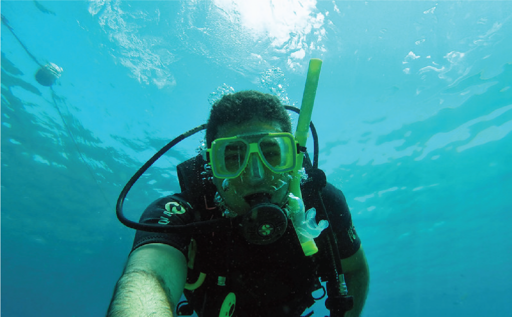 man holding camera underwater selfie